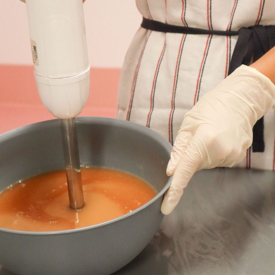 Hands mixing a batch in the JouJou Botanicals workshop